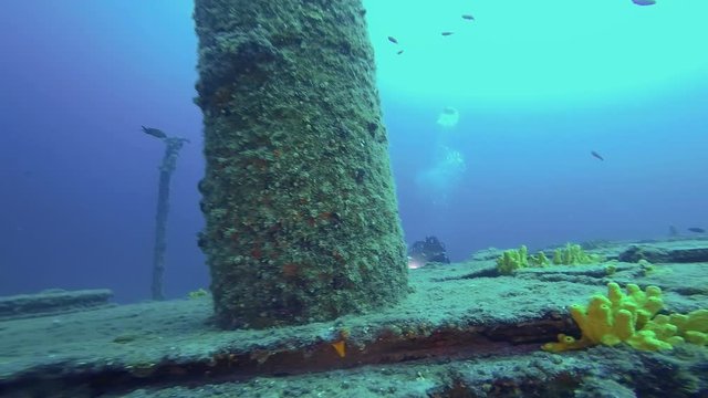 Scuba Divers Exploring A Large Shipwreck