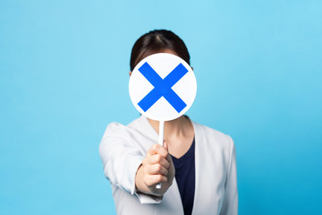 バツを見せる女性