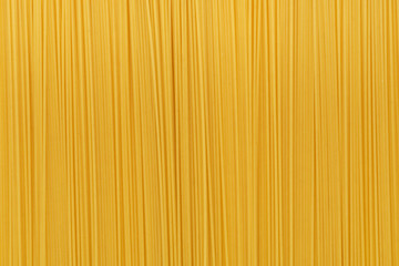 Dry uncooked spaghetti pasta as a background.