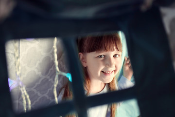 Cute little girl sitting in shelter at night