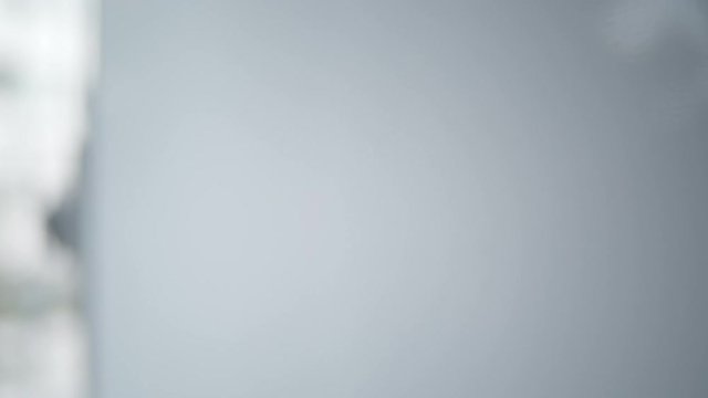 Close-up of a man's hand erasing angled line from whiteboard