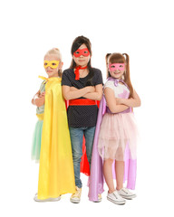 Cute little children dressed as superheroes on white background