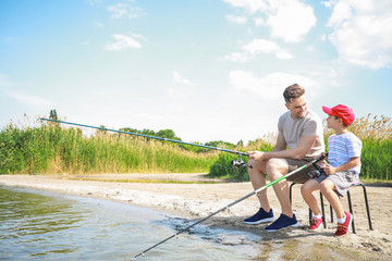 Father and son fishing together on river