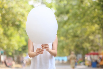Woman with sweet cotton candy outdoors