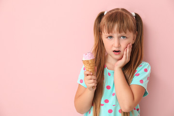 Little girl with sensitive teeth and cold ice-cream on color background - obrazy, fototapety, plakaty