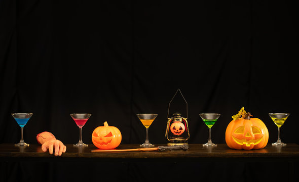Halloween pumpkin and wine glass on the black background prepare to celebrate on Halloween
