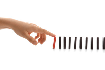 Female hand pushing dominoes on white background