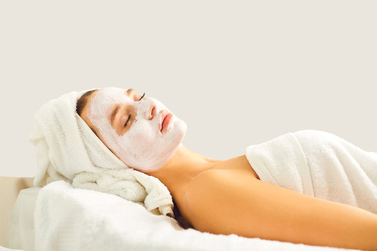 A woman in cosmetologic mask on a gray background.