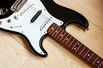 Electrobic guitar on the wooden floor. Musical concept with guitar body.