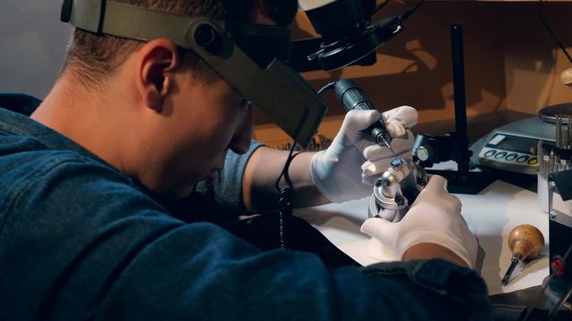 Goldsmith is processing a ring with a jewel. Jeweler Working jewelry