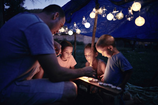 Father With Children Playing Under Their Backyard Tent.