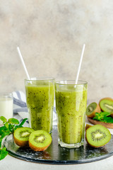 Glasses of tasty kiwi smoothie on table