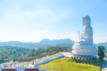 Big white bodhisattva guanyin statue with blue sky background at Wat Huai Pla Kung temple, Chiang rai,Thailand.Asian Landscape famous landmark.Religion buddha praying fortune, wealth, money concept