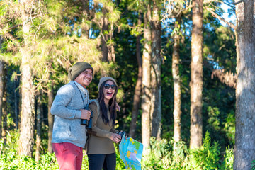 Fototapeta premium The happy man and woman who are spouse are laughing while they are traveling into the wild in the morning on vacation.