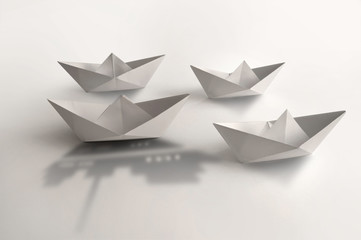 Leader concept,  paper boat cruise ship shadow