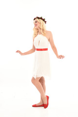 full length portrait of blonde girl wearing a white dress and flower crown.  Standing pose, isolated against a  white studio background.
