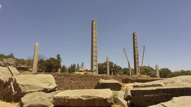Retreating low angle drone shot of obelisk pillars (historically used as markers for burial chambers) in the former Kingdom of Aksum, historic landmark destination in Ethiopia Africa
