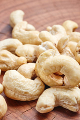 Close up picture of cashews on a wooden table, selective focus.