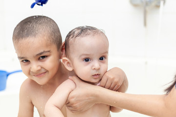 Two brothers having water fun in bath