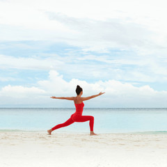 Yoga outdoor. Happy woman doing yoga exercises, meditate on the beach. Yoga meditation in nature. Concept of healthy lifestyle and relaxation. Pretty woman practicing yoga near the sea
