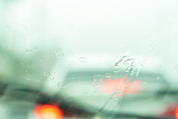 Abstract blurred of traffic jam with rain drops on window ,rain and bokeh .Many cars on expressway in the city during rush hour .City lifestyle rush hour concept