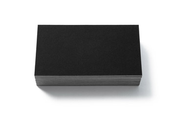 Blank black business card isolated on white background. Front view. Standard size. Stylish textured stack of cardboard for personal advertising or corporate design. 