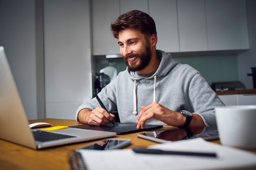 Cheerful young graphic desginer working late from home