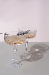 Beautiful crystal champagne glasses with lavender grey minimalistic background vertical shot with space for design