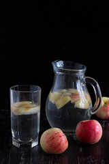 Apple kompot in glass bottle on the black background