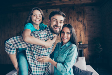 Close up photo of charming mom dad girl with long brunette hair piggybacking smiling wearing...