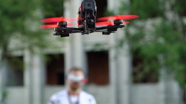 Male pilot manages FPV freestyle drone in flight