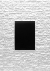 Modern bright mock up black marble on white brick with vertical empty frame hang on wall.