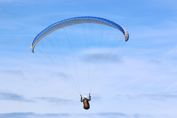 Paraglider flying blue wing