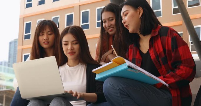 A group of beautiful Asian students girl sitting and using notebook computer for their entertainment in school.