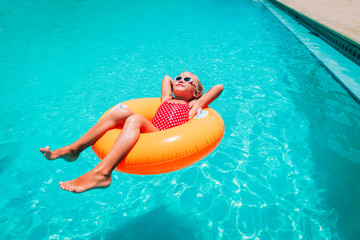 cute little girl have fun at the pool, child relax in floatie