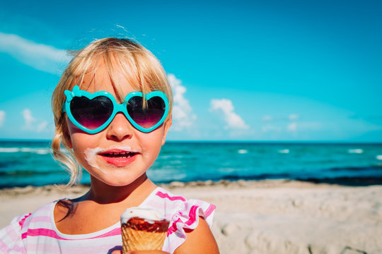 Happy Cute Girl Eating Ice Cream On Beach