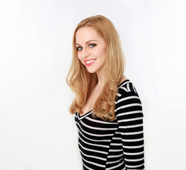 3/4 portrait of pretty blonde lady wearing stripes shirt, isolated against a white studio background.