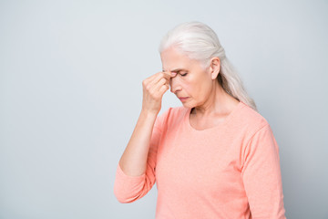 Photo of sad upset suffering from acute pain in head near nose granny wearing peach color pullover...