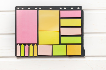 Paper stickers multicolored and different shapes on a black paper base