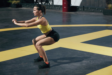 Fototapeta na wymiar Fitness woman exercising, doing squat exercise workout outdoor