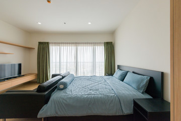Fototapeta na wymiar Bright and cozy modern bedroom with dressing room