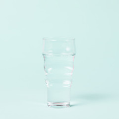 Minimalist glass of water on blue background
