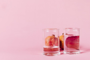 Fototapeta na wymiar Pomegranate behind glasses with water