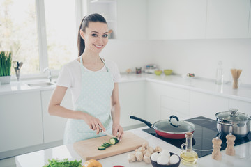 Photo of happy rejoicing mother cooking breakfast for her children while they are sleeping in modern cozy kitchen