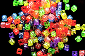 Fototapeta na wymiar Engish letter on colorful cubic beads isolate on black background.