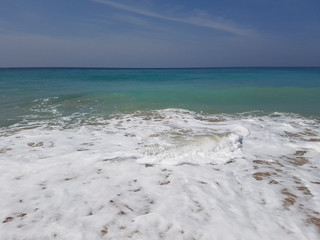 Deserted paradise beach with foamy waves