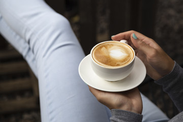 Close-up of woman holding coffee cup and plate