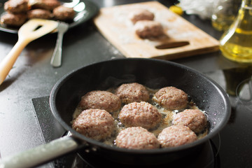 Cutlet from minced meat is cooking in frying pan.