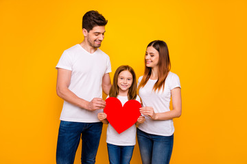 Fototapeta na wymiar Daddy mommy and little foxy lady posing for family portrait with big paper heart wear casual clothes isolated yellow background