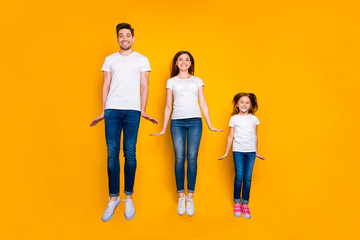 Fototapeta premium Full length body size view of three nice attractive slim fit sporty healthy cheerful cheery person having fun jumping up holiday isolated over bright vivid shine yellow background